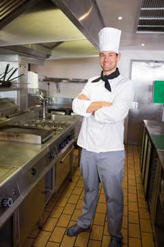 Smiling male cook with arms crossed in the kitchen