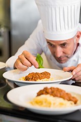 Male chef garnishing food in kitchen