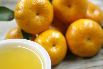 cup of fresh orange juice and oranges on a vintage wooden