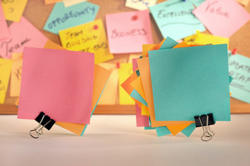 Paper notes fastened with paper clips, message board.