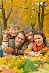 Fototapeta premium Happy family lying in autumn park