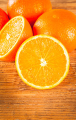 Fresh orange fruits and slices on wooden table. Wooden backgroun