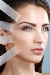 Beautiful woman applying tape lifting treatment on face - 61853675