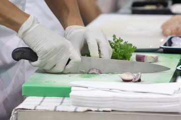 Closeup of woman cutting onion on cutting board