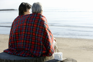Japanese husband and wife nestling up on beach