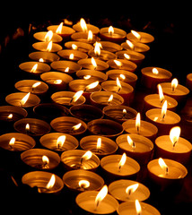 wax candles lit by the faithful during the celebration of the Eu - obrazy, fototapety, plakaty