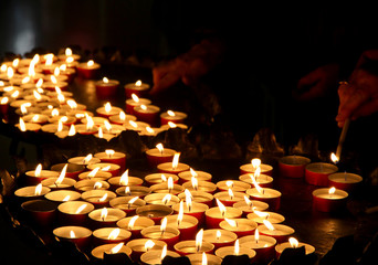 hands of an elderly woman lighting a candle
