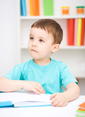 Little boy is reading a book