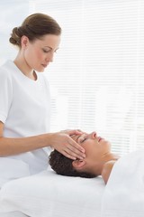 Fototapeta na wymiar Female therapist giving head massage to woman