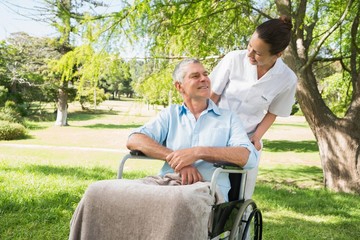 Woman with her father sitting in wheel chair at park