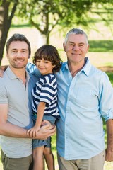 Naklejka premium Grandfather father and son smiling at park