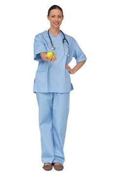 Smiling Nurse In Scrubs Holding Green Apple