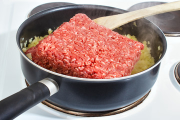 Starting to cook raw minced meat in a frying pan