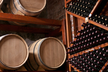 Wine Barrels and bottles on shelf in a Cellar