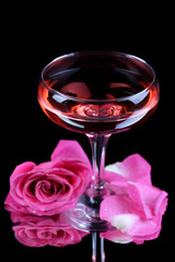 Composition with pink sparkle wine in glass and  rose isolated