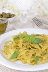 Delicious pasta with pesto on plate on table close-up