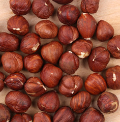 Close up of hazel nuts on a wooden board.