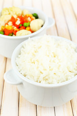 Cooked rice with vegetables on wooden table close up