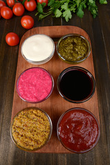 Various sauces on chopping board on table close-up