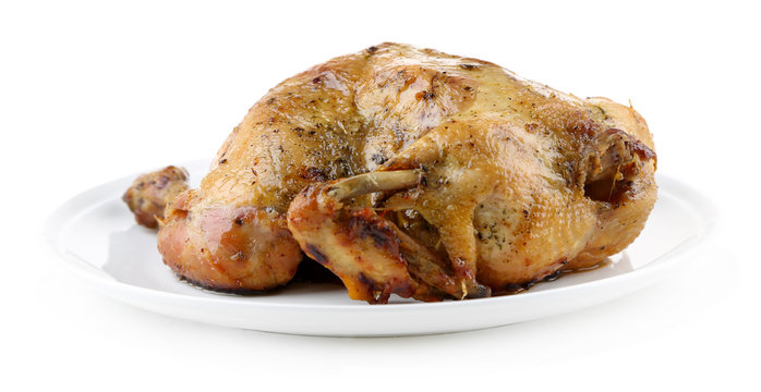 Whole roasted chicken on plate, isolated on white