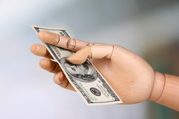 Money in wooden hand, on light background