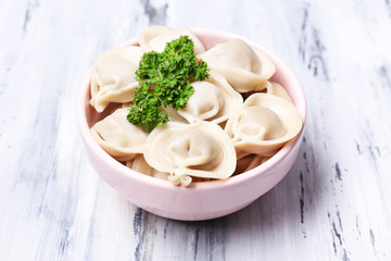 Meat dumplings - russian boiled pelmeni on wooden table