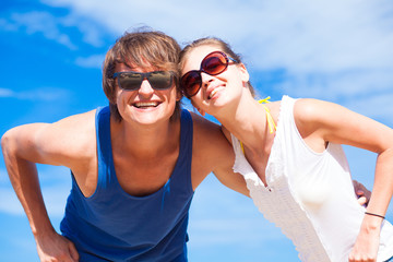 Closeup of happy young couple in sunglasses smiling on tropical