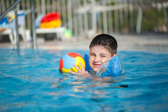 boy in the swimming pool with ball