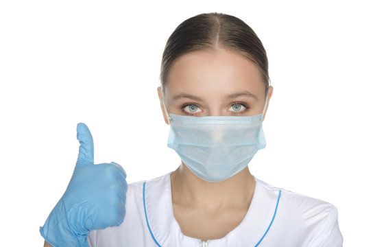 Doctor in blue gloves and mask raised thumb