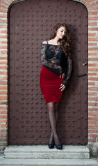 Charming young brunette woman in black blouse and red skirt 