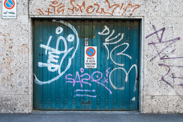 Porta garage verde con graffiti