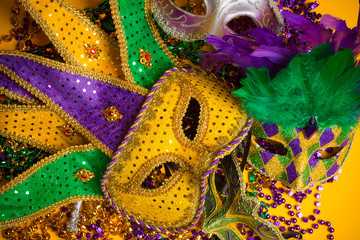 Colorful group of Mardi Gras or venetian masks on yellow