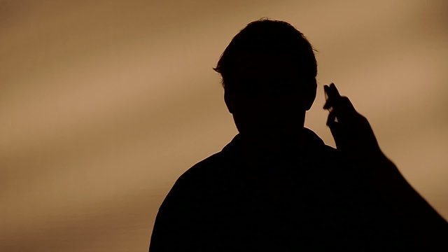 Male silhouette calling on the phone.