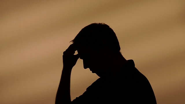 Male silhouette scratching his head