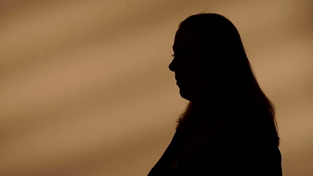 Female silhouette talking with hands. You or me? I don't know!
