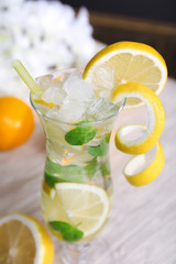 Glass of cocktail with lemon and mint on table close-up