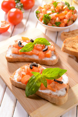 Delicious bruschetta with tomatoes on cutting board close-up