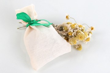 Obraz na płótnie Canvas Textile sachet pouch with dried flowers isolated on white