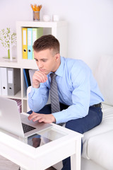 Fototapeta premium Handsome young man working on laptop at home