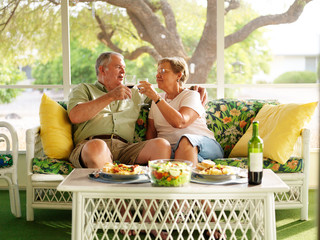 elderly couple drinking wine with their dinner