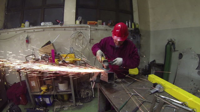 Worker in Action With Angel Grinder.