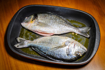 A pair of sea bream ready to be cooked in the oven