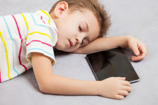 Tired Sleeping Child Boy Holding Tablet Computer