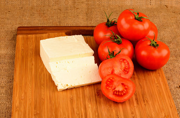 cheese and tomatoes on a cutting board