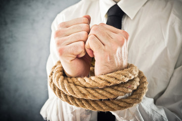 Businessman with hands tied in ropes - obrazy, fototapety, plakaty