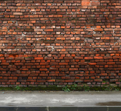 Old Weathered Brick Wall With Sidewalk