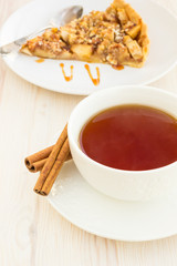 Cup of tea with delicious fresh baked  apple pie on a wooden sur