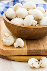 Fresh mushrooms in a cup on a wooden surface