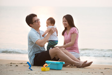 chinese asian family playing on the beach