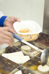 hand of convenience store salesclerk who scoops up Japanese pot-au-feu